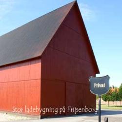 På billedet ser du en imponerende stor ladebygning beliggende på Friesenborg, som fremstår i en dyb og varm rustrød nuance. Farven på bygningen er et fremragende eksempel på Morsø Malings kvalitetsprodukter, her demonstreret med deres ypperlige rustrøde udendørsmaling. Det er denne type maling, der sørger for at store trækonstruktioner som denne får en langvarig og holdbar beskyttelse. På bygningen fremgår et skilt med teksten 