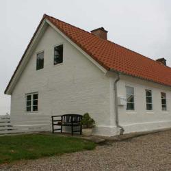 Perlemor hvidt hus malet med Morsø Maling facademaling, der fremhæver strukturen og volumen på bygningens facade.