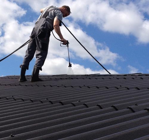 Privatperson, der er på taget og selv maler sit tag efter at bruge guiden 