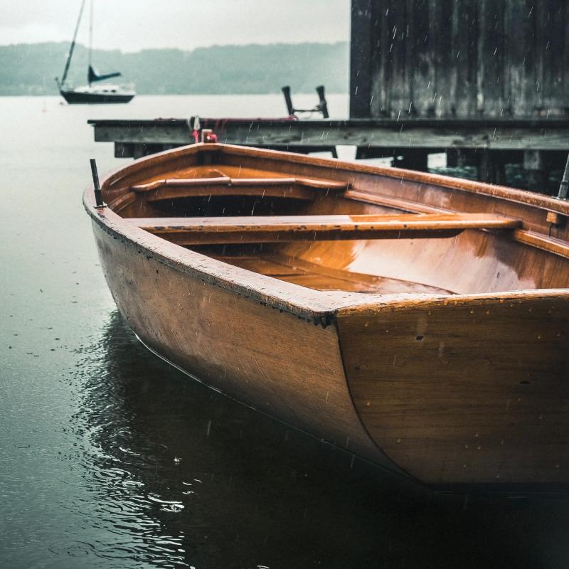 Lille træbåd på vandet efter at have fået linolie til træskibe.