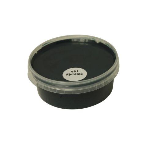 Billedet viser en rund farveprøve bøtte med maling i en ensartet, livlig og klar fjeldblå farve. Overfladen fremstår dækkende og jævn, hvilket giver et realistisk indtryk af farvens udtryk på malede overflader. Farveprøven anvendes til at vurdere nuance, dækkeevne og finish før valg af maling til større projekter. Den blå farve repræsenterer en af de farvenuancer, som findes i udvalget af træbeskyttelse.