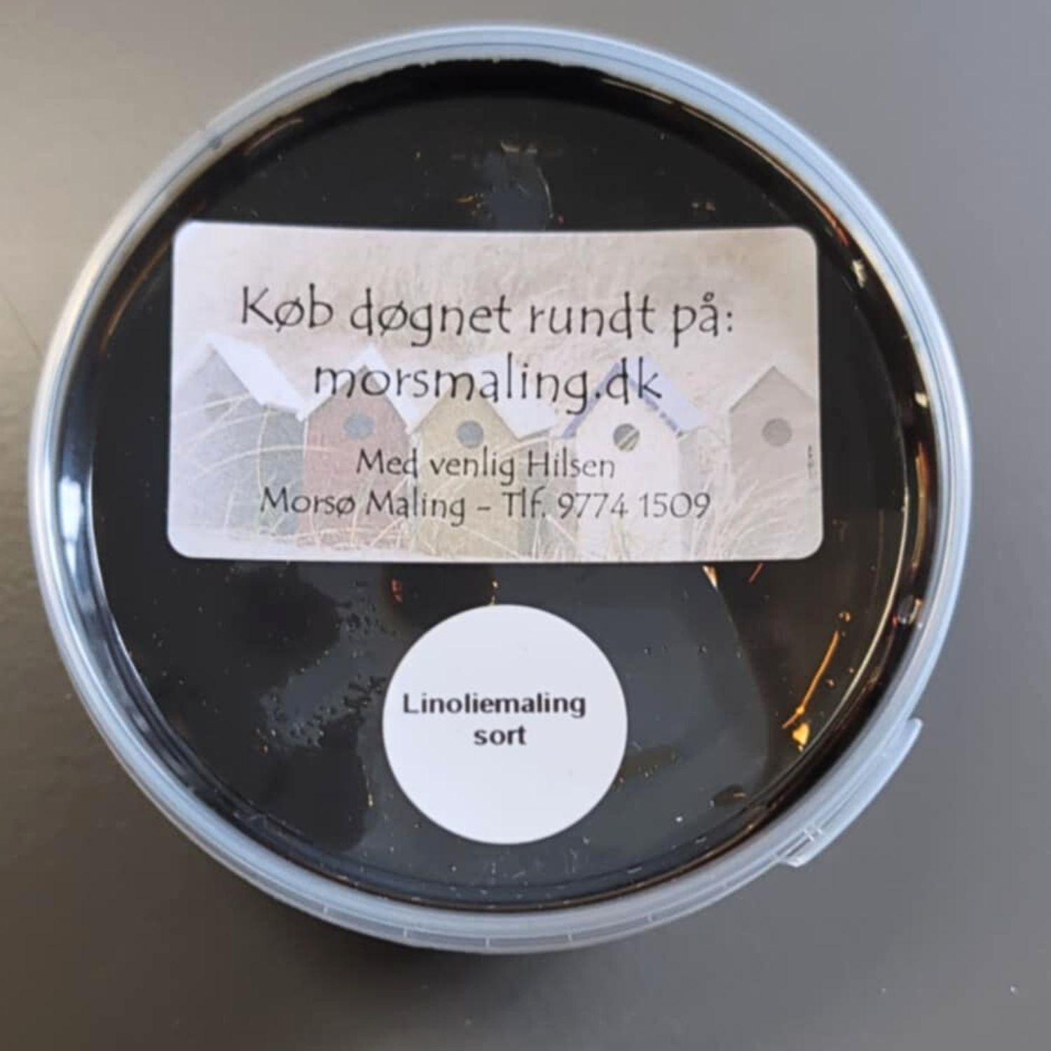 En lille prøve bøtte linoliemaling på et bord med grå baggrundsfarve. 